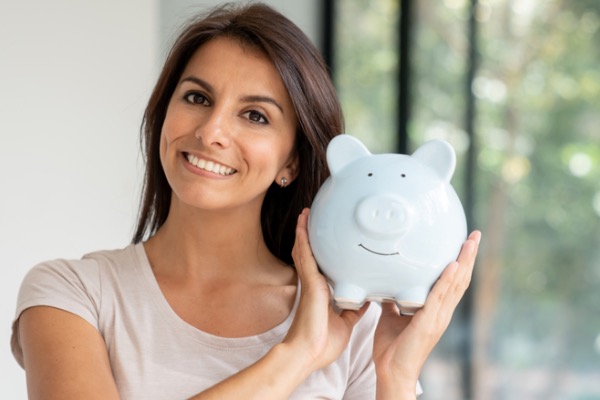 Woman holding a piggy bank near her face